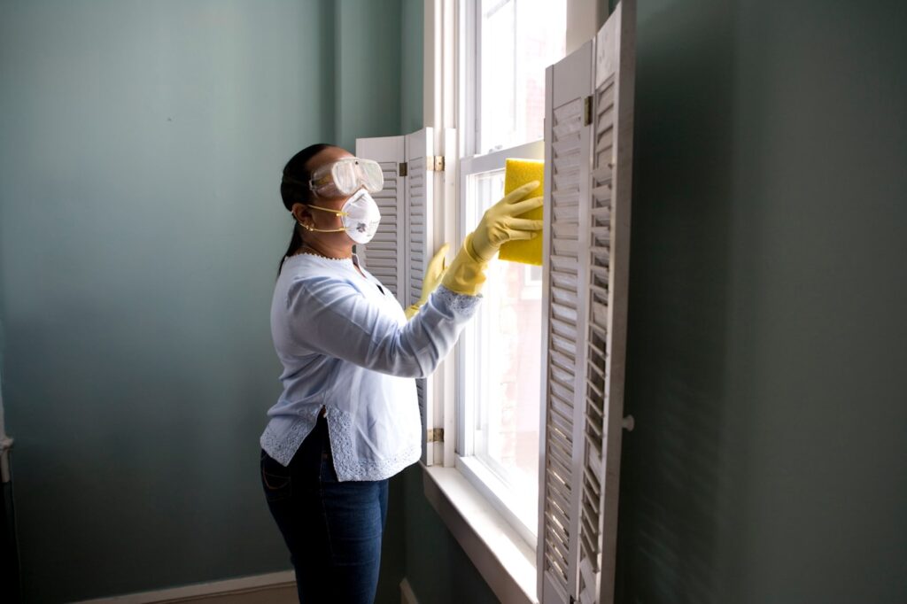 Cleaning professional wiping a home window